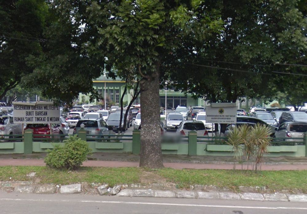Tussen de bomen herkennen we het kantoor van de Deli Mij. , nu een Rumah Sakit Militer